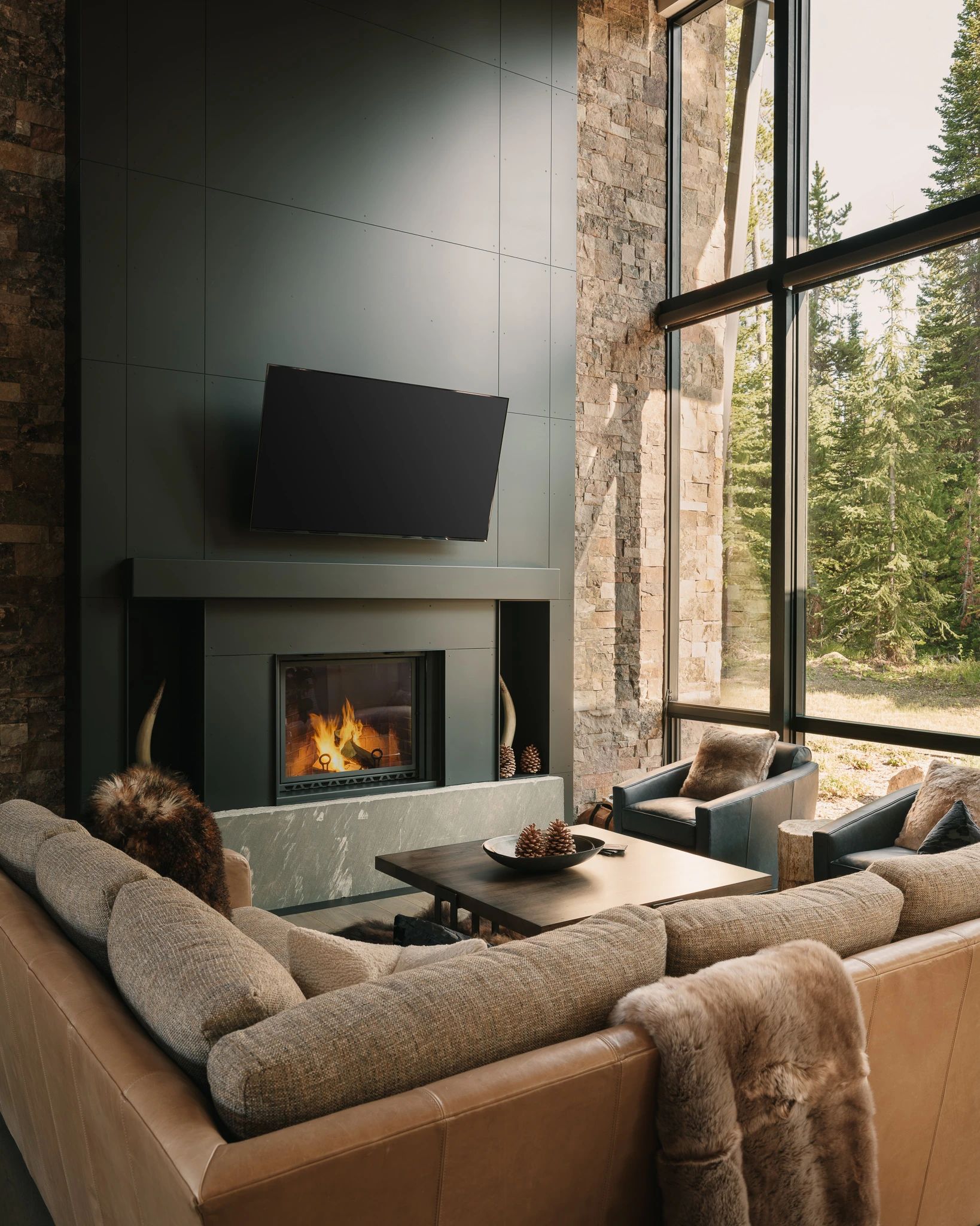 Great room fireplace flanked by blue leather chairs — interior design photography Big Sky Montana, Speedwell Cabin